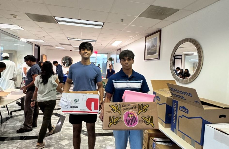 Volunteers carrying packed boxes